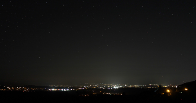 Photo de nuit avec colline et vue sur les lumières de la ville